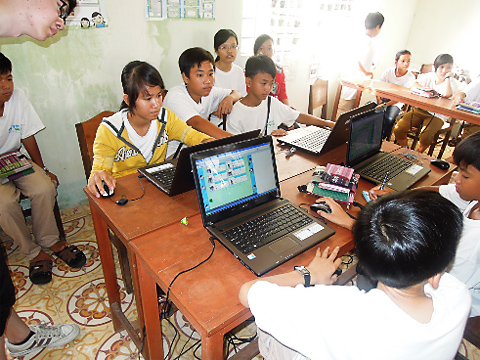 写真１　村の公民館でPCを使って、専門家と質問・回答をやりとりする子供たち