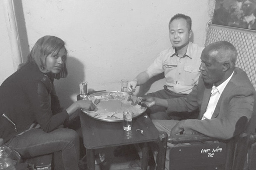 写真1　インジェラを同僚と一緒に食べる筆者