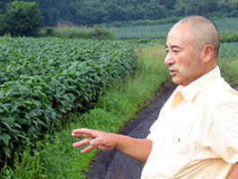 写真2 大白種の大豆畑の前で村おこしを語る